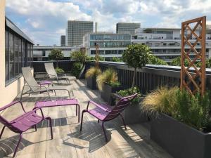 a patio with purple chairs and tables on a balcony at Mercure Paris Bercy Bibliothèque in Paris