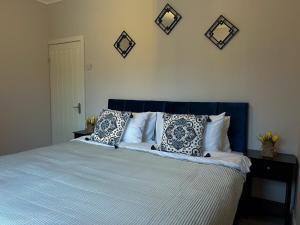 een bed met een blauw hoofdeinde en kussens erop bij Charming, spacious and cosy home in HULL in Hull