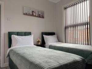 two beds sitting next to each other in a room at Charming, spacious and cosy home in HULL in Hull