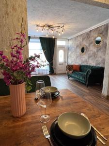 een eetkamer met een tafel en een bank bij Charming, spacious and cosy home in HULL in Hull