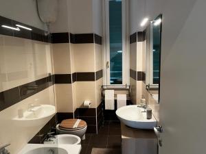 a bathroom with two sinks and a toilet at Be Your Home - MR House in Rome +35 photos