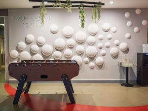 a wall with a ping pong table in a room at ibis Styles Lyon Sud Vienne in Chasse-sur-Rhône