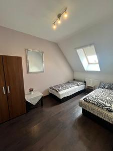 a bedroom with two beds and a mirror and a window at Rédiapartmanok in Budapest