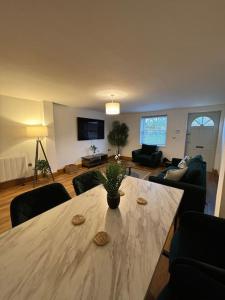 a living room with a table and a living room with a couch at 3 Cherry Tree Cottages in Stock