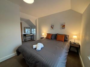 a bedroom with a large bed with two lamps at 3 Cherry Tree Cottages in Stock