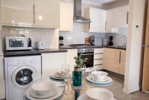 GuestReady - Beautiful apartment on Dublin Coast في دبلن: مطبخ مع طاولة مع الأطباق وكؤوس النبيذ