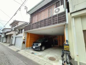 samochód jest zaparkowany w garażu w obiekcie Long Stay Takayama w mieście Takayama