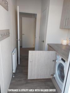 a laundry room with a washing machine in a room at Greenshaw - extremely spacious in Rye Harbour