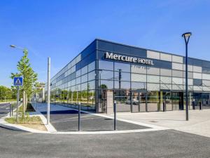 un grand bâtiment en verre avec un hôtel de qualité dans l'établissement Mercure Paris Orly Airport, à Orly