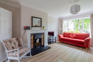 a living room with a red couch and a fireplace at GuestReady - A charming place near Golf Centre in Dublin