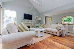 a living room with two couches and a table at GuestReady - Opulence Malahide Seaside Cottage in Malahide