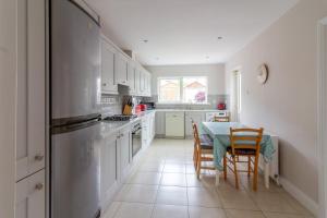 a kitchen with a table and chairs and a refrigerator at GuestReady - A charming place near Golf Centre in Dublin