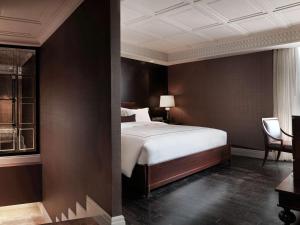 曼谷的住宿－美憬阁曼谷缪斯廊双酒店，一间卧室配有一张床和一把椅子