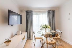 马拉海德GuestReady - Impressionante Flat com Vista Terraço的一间有桌子、椅子和窗户的餐厅