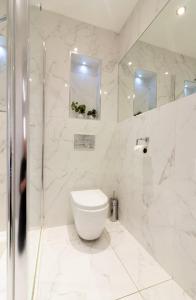 a white bathroom with a toilet and a shower at GuestReady - Impressionante 2BR Flat com Vista Terraço e Mar in Malahide