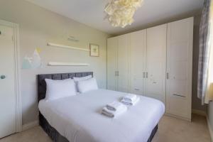 a bedroom with a large white bed with towels on it at GuestReady - Tranquil Retreat in Kimmage in Crumlin