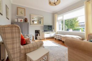 a living room with a couch and chairs and a window at GuestReady - Tranquil Retreat in Kimmage in Crumlin