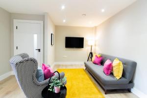 a living room with a gray couch and pink and yellow pillows at Guestready - Encantando 1BR Flat no Newmarket Hall in Dublin