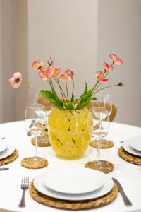 un tavolo con un vaso giallo con dei fiori di Guestready - Encantando 1BR Flat no Newmarket Hall a Dublino
