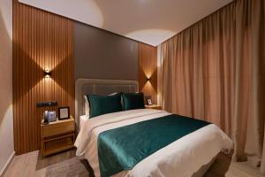 Appart Hôtel Rambla في مراكش: غرفة نوم بسرير كبير ومخدات خضراء