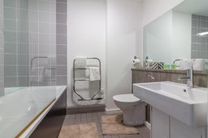 a bathroom with a sink and a toilet and a tub at GuestReady - Royal Canal Park Chic Getaway in Dublin