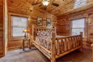 1 dormitorio con 1 cama en una cabaña de madera en Dreams Come True With This Luxury Cabin!, en Gatlinburg