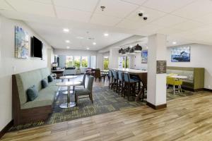 a lobby with tables and chairs and a dining room at Hampton Inn Port Charlotte in Port Charlotte