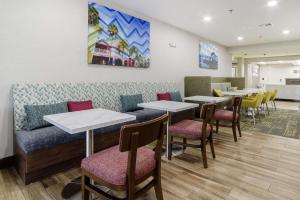 a restaurant with tables and a couch and chairs at Hampton Inn Port Charlotte in Port Charlotte