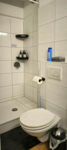 La salle de bains blanche est pourvue d'une douche et de toilettes. dans l'établissement PRIVATE ROOM in a Shared Cozy Flat, à Düsseldorf