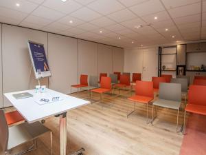 a conference room with orange chairs and a white table at ibis budget Nice Californie Lenval in Nice