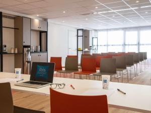 an office with a laptop on a table with chairs at ibis budget Nice Californie Lenval in Nice