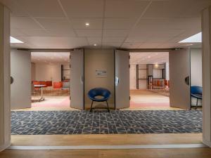 a hallway with a blue chair in a room at ibis budget Nice Californie Lenval in Nice