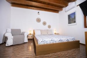 a bedroom with a bed and a chair at Montesanto 13 in Palermo