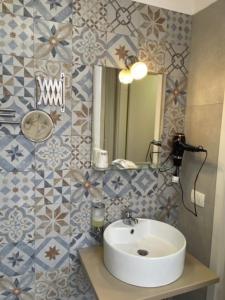 Umberto House Catania في كاتانيا: حمام به حوض وبلاط ازرق وابيض