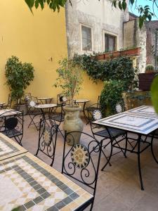 カターニアにあるUmberto House Cataniaのテーブルと椅子、花瓶のあるパティオ