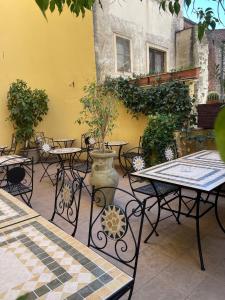 un patio con tavoli, sedie e un vaso di Umberto House Catania a Catania