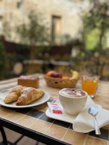 Umberto House Catania في كاتانيا: طاولة مليئة بفنجان من القهوة والكرواسان