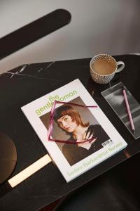 una rivista seduta su un tavolo con una tazza di caffè di QT Perth a Perth