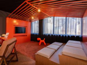 Zimmer mit einem Bett, einem Tisch und einem TV in der Unterkunft Novotel Suites Colmar Centre in Colmar