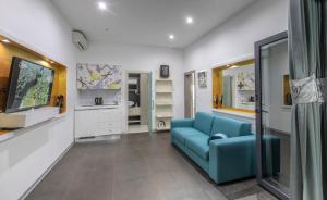 a living room with a blue couch and a tv at Luxury Villa M in Rogoznica