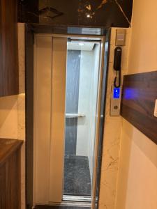 a bathroom with a shower with a glass door at Airport Hotel Relax Inn in Nagpur