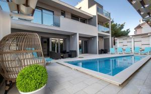 a house with a swimming pool in front of a house at Luxury Villa M in Rogoznica