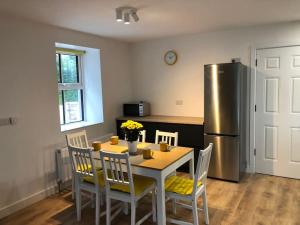 Il comprend une cuisine équipée d'une table, de chaises et d'un réfrigérateur. dans l'établissement Sunville Cottage, à Limerick