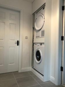 una lavandería con lavadora y secadora junto a una puerta en Sunville Cottage, en Limerick