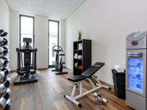 einen Fitnessraum mit einem Laufband und einem Stuhl in einem Zimmer in der Unterkunft Aparthotel Adagio Bremen City in Bremen