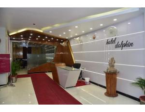 a lobby with a red carpet and a staircase in a building at Hotel Dolphin, Udhampur in Udhampur