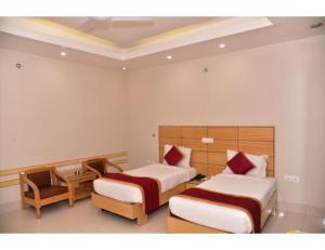 a hotel room with two beds and a table at Hotel Dolphin, Udhampur in Udhampur