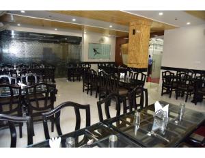 a dining room with tables and chairs in a restaurant at Hotel Dolphin, Udhampur in Udhampur