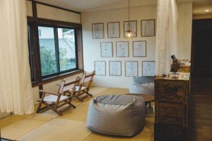a living room with a table and chairs and a window at Masukichi -hostel,cafe,souvenir,guide- in Seto