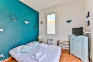 a bedroom with a bed with a blue wall at Résid'Azur - T2 résidentiel avec piscine in Saint-Jean-de-Monts